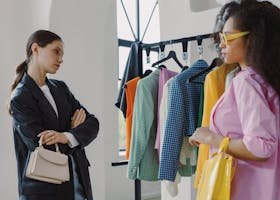 Two women browsing colorful clothing racks in a modern boutique.
